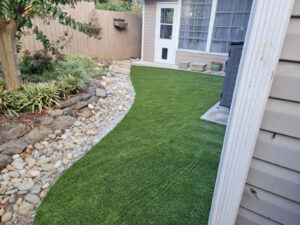 Vibrant synthetic turf lawn enhancing a residential backyard, showcasing lush greenery and precise installation for a natural look